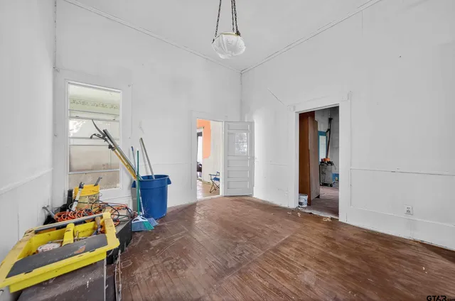 a view of an empty room with furniture and a window