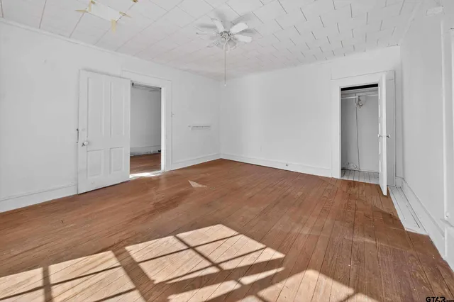 a view of a hallway with wooden floor and windows