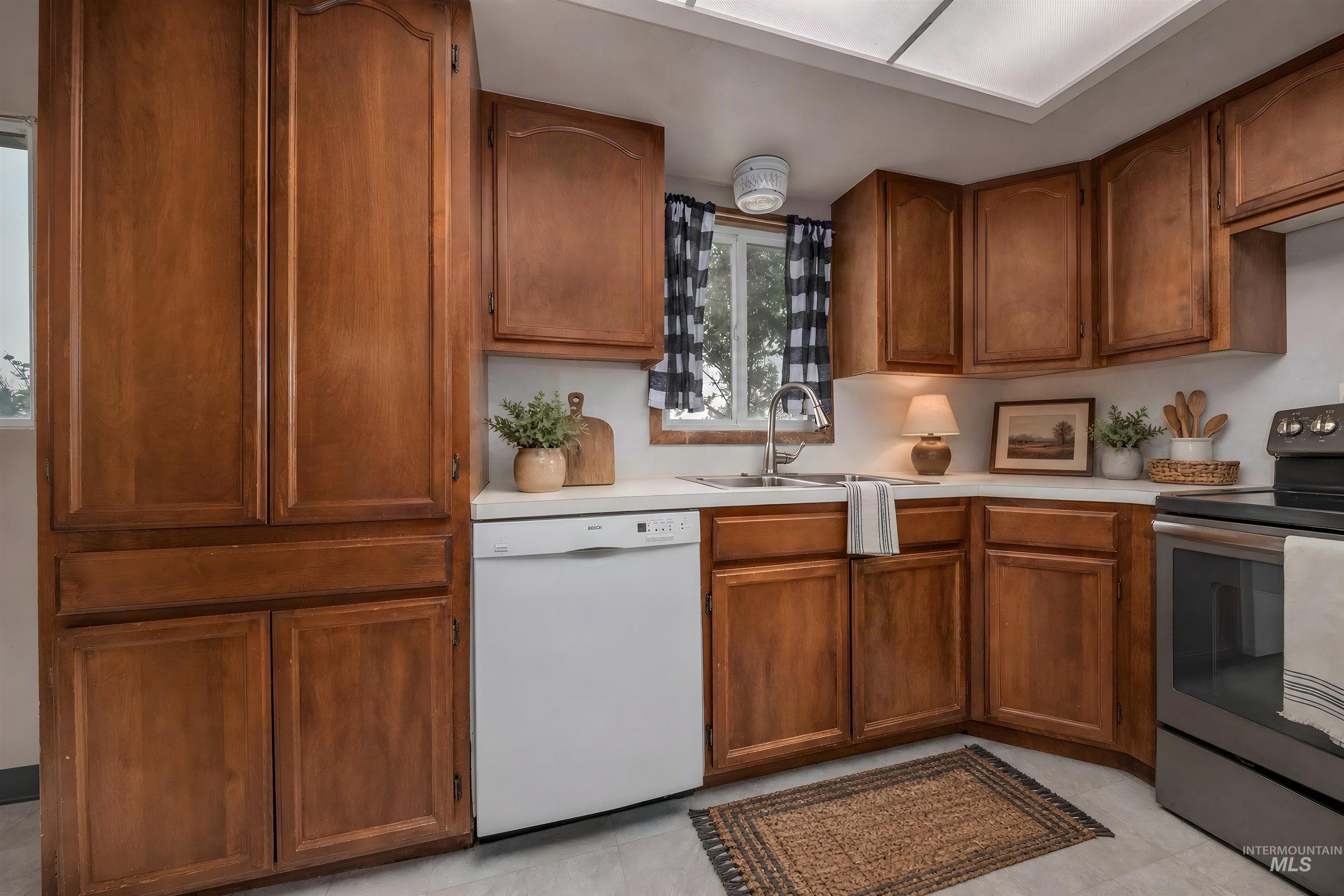 1741 Cove Road Weiser, ID 83672 - Photo 13 of 46 Kitchen featuring extensive wood cabinetry, solid surface countertops, a stainless steel range, and a built-in dishwasher