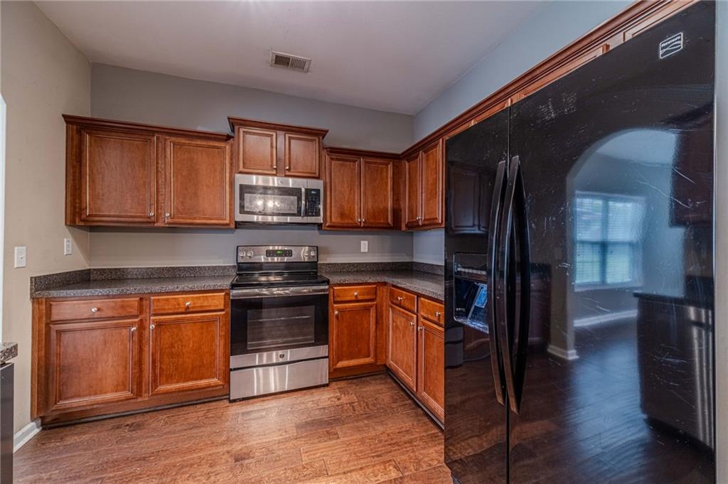 6503 Silk Tree Pointe Braselton, GA 30517 - Photo 11 of 47 a kitchen with stainless steel appliances granite countertop a stove a sink and a refrigerator