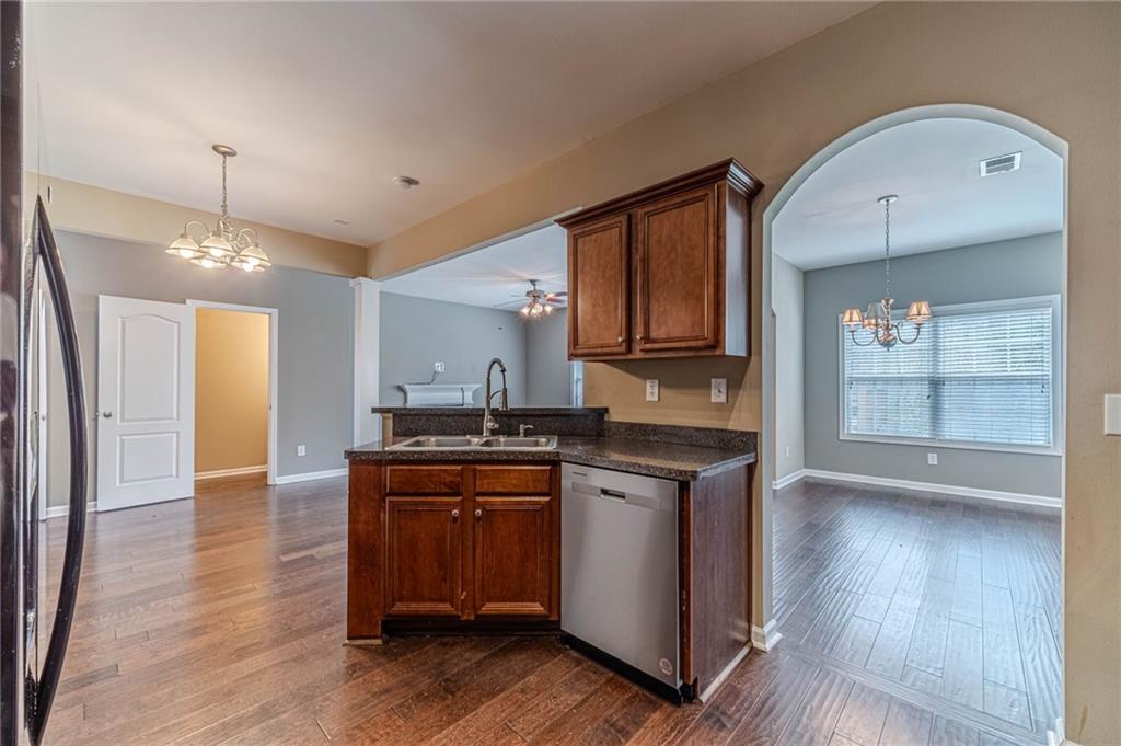 6503 Silk Tree Pointe Braselton, GA 30517 - Photo 13 of 47 a kitchen with stainless steel appliances granite countertop a sink a stove and a wooden floors