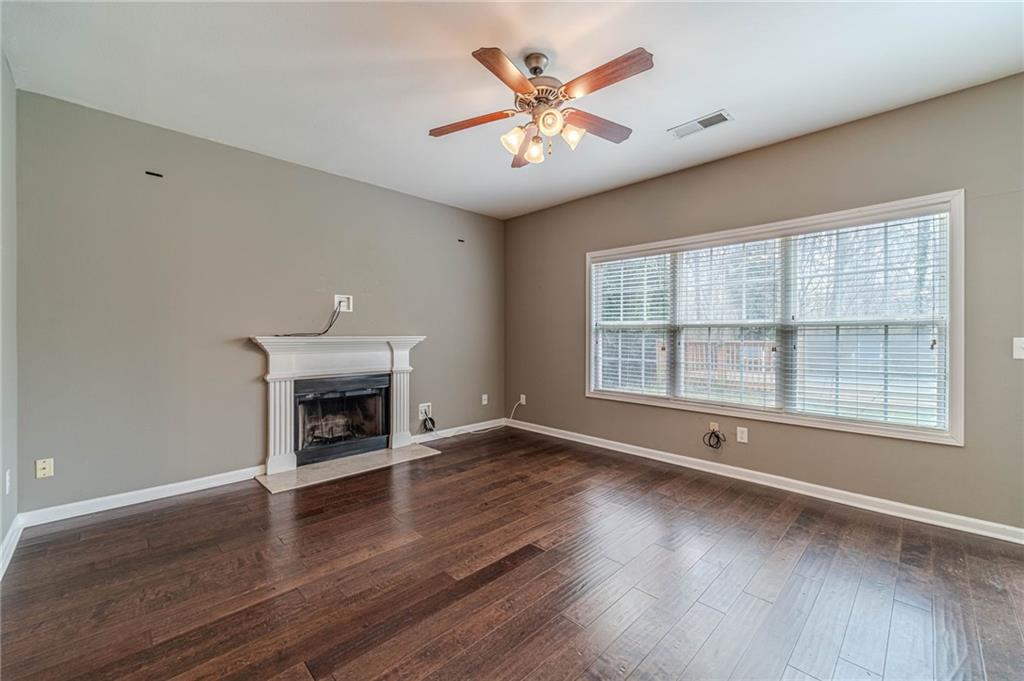 6503 Silk Tree Pointe Braselton, GA 30517 - Photo 18 of 47 an empty room with windows fireplace and wooden floor