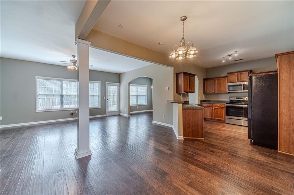 6503 Silk Tree Pointe Braselton, GA 30517 - Photo 6 of 47 an open kitchen with wooden floor and stainless steel appliances