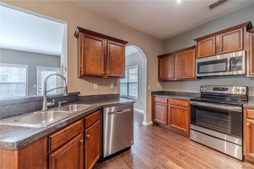 6503 Silk Tree Pointe Braselton, GA 30517 - Photo 10 of 47 a kitchen with stainless steel appliances granite countertop a sink stove microwave and cabinets