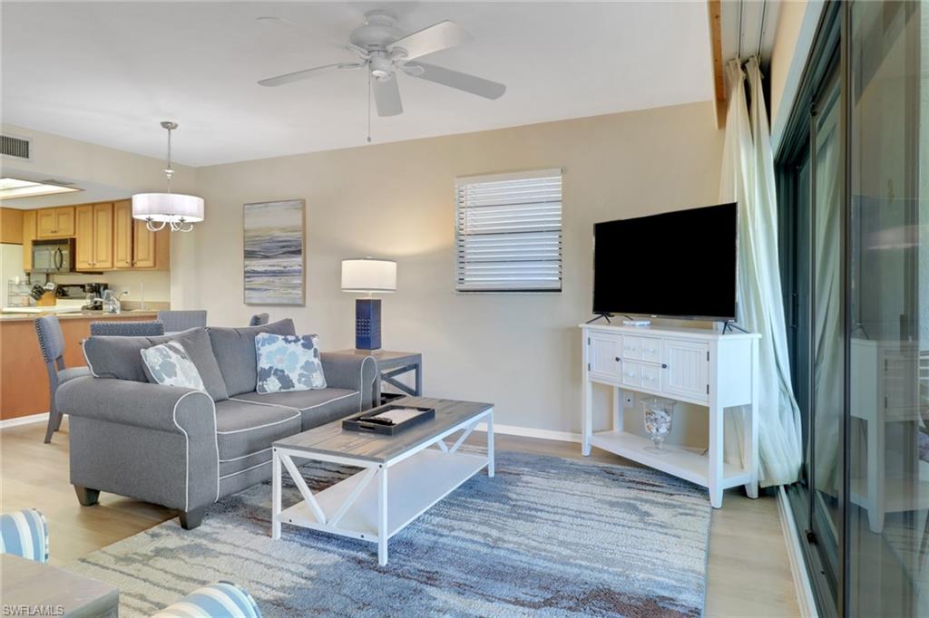 600 Neapolitan Way, Unit 345 Naples, FL 34103 - Photo 12 of 43 Living room featuring light wood-style floors, ceiling fan, and baseboards