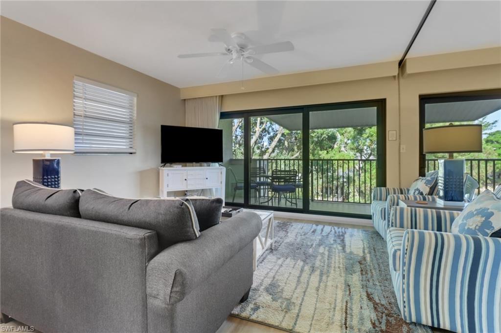 600 Neapolitan Way, Unit 345 Naples, FL 34103 - Photo 13 of 43 Living area featuring a ceiling fan and wood finished floors