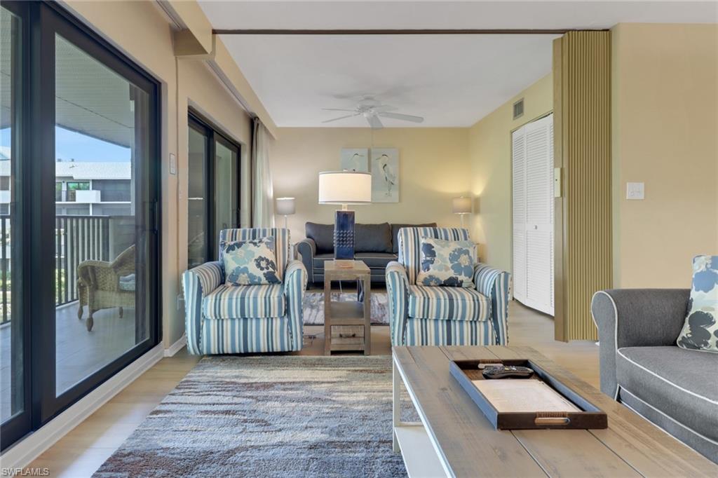 600 Neapolitan Way, Unit 345 Naples, FL 34103 - Photo 15 of 43 Living room with ceiling fan and light wood-style flooring