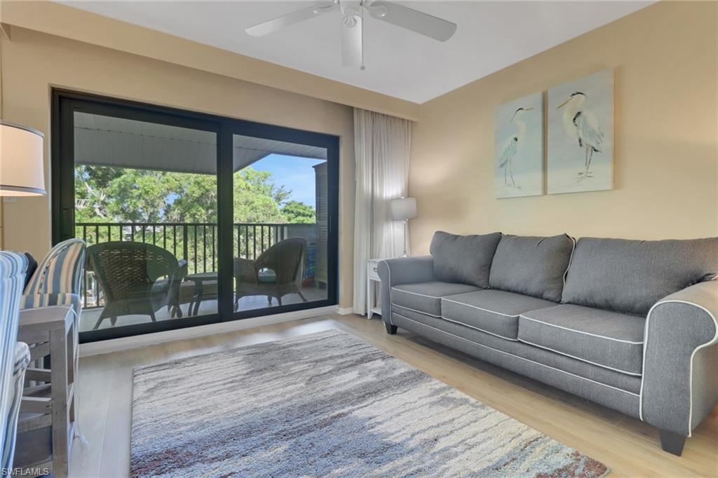 600 Neapolitan Way, Unit 345 Naples, FL 34103 - Photo 16 of 43 Living area with ceiling fan and wood finished floors