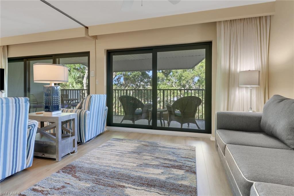 600 Neapolitan Way, Unit 345 Naples, FL 34103 - Photo 17 of 43 Doorway to outside featuring wood finished floors and ceiling fan