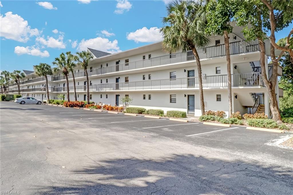 600 Neapolitan Way, Unit 345 Naples, FL 34103 - Photo 29 of 43 View of property with uncovered parking and stairs
