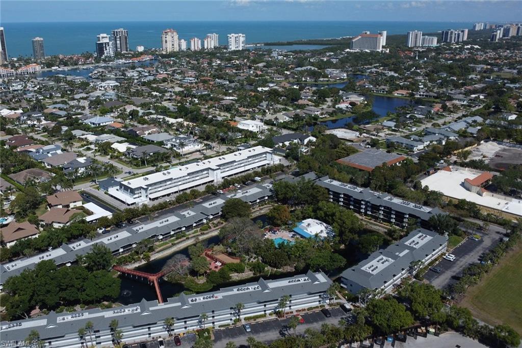600 Neapolitan Way, Unit 345 Naples, FL 34103 - Photo 31 of 43 Aerial overview of property's location featuring a large body of water and nearby urban area