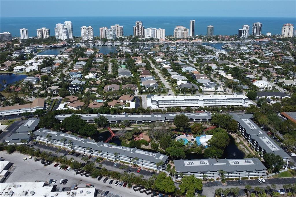 600 Neapolitan Way, Unit 345 Naples, FL 34103 - Photo 32 of 43 Aerial view of property's location featuring a large body of water and nearby urban area