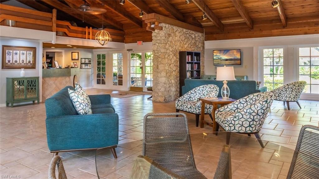 600 Neapolitan Way, Unit 345 Naples, FL 34103 - Photo 37 of 43 Living area featuring wooden ceiling, beam ceiling, a chandelier, french doors, and high vaulted ceiling