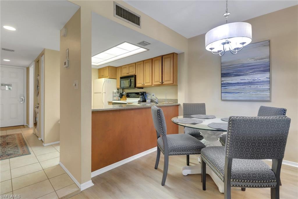 Dining space with a chandelier, baseboards, light tile patterned floors, and recessed lighting