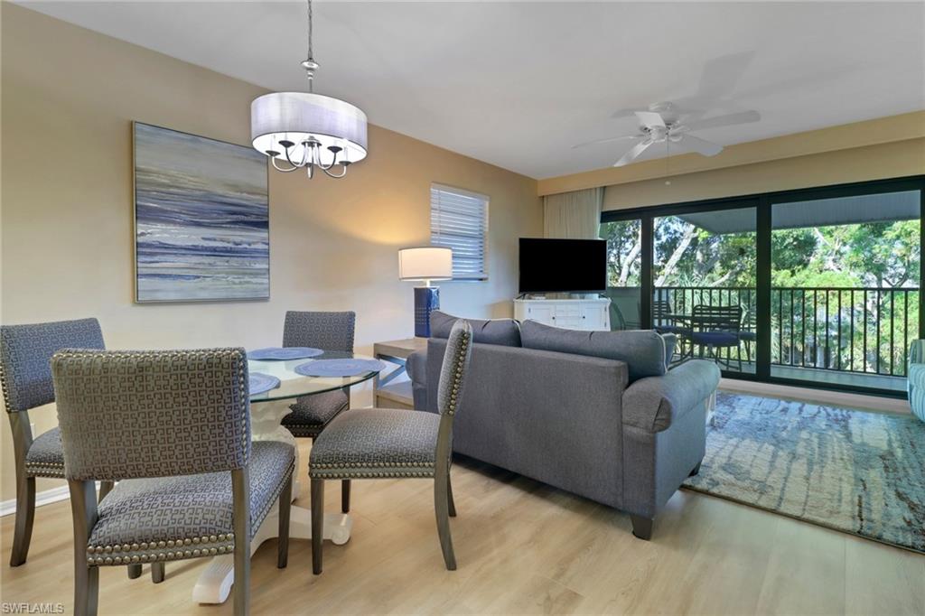 Dining space with light wood-style floors, a ceiling fan, and a chandelier