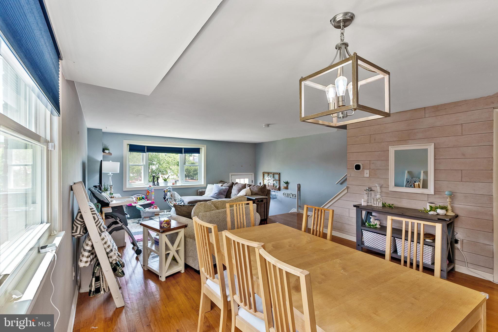 5633 Chelwynd Road Halethorpe, MD 21227 - Photo 14 of 41 a dining room with wooden floor windows and a chandelier