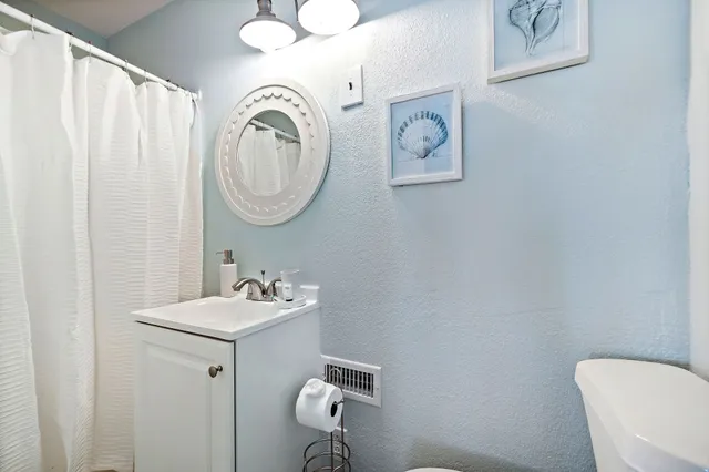 a bathroom with a toilet a sink and a mirror