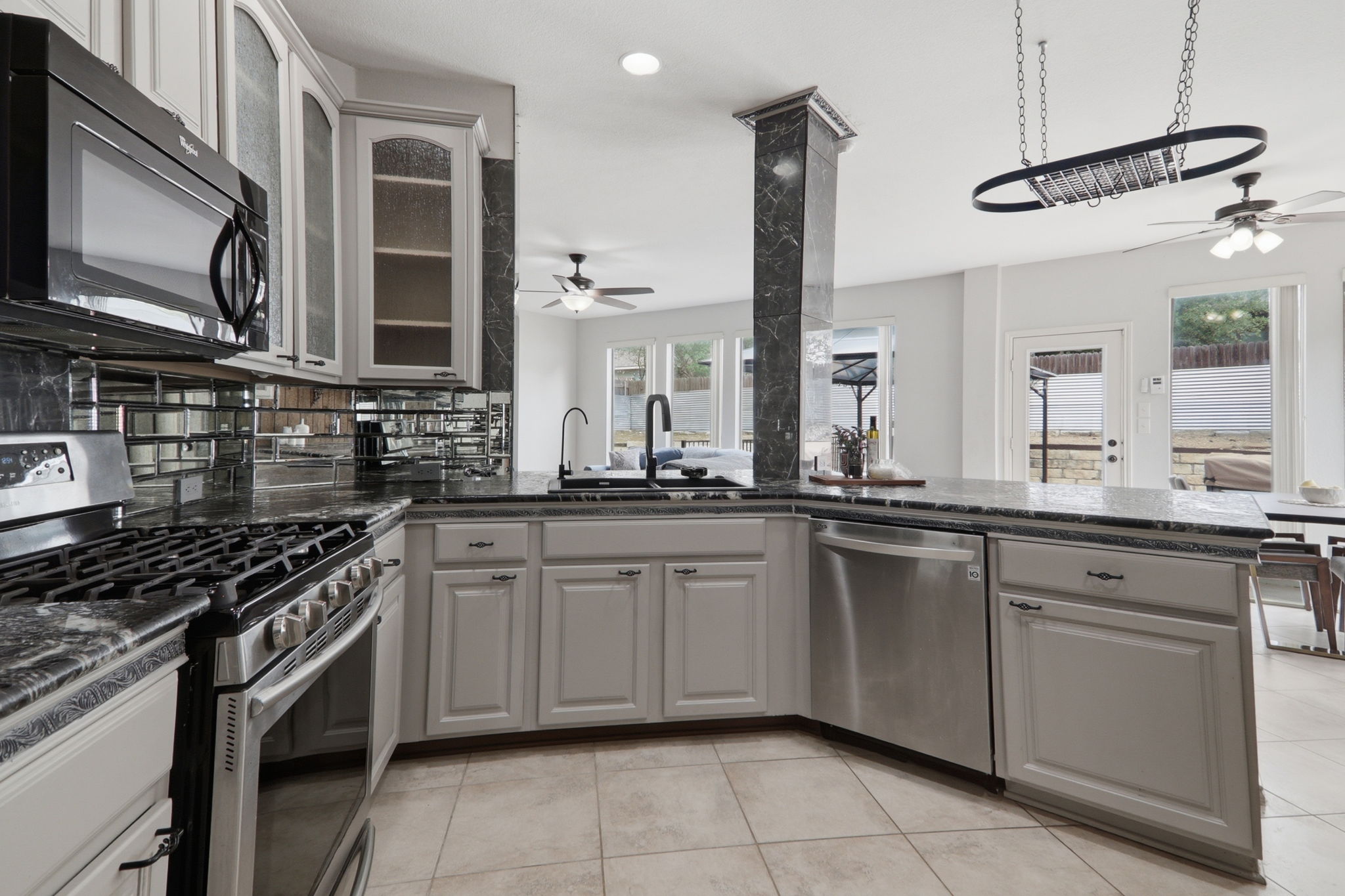 500 Red Hawk Drive Leander, TX 78641 - Photo 35 of 35 Kitchen with stainless steel appliances, a ceiling fan, glass fronted cabinets, gray cabinets, and open floor plan