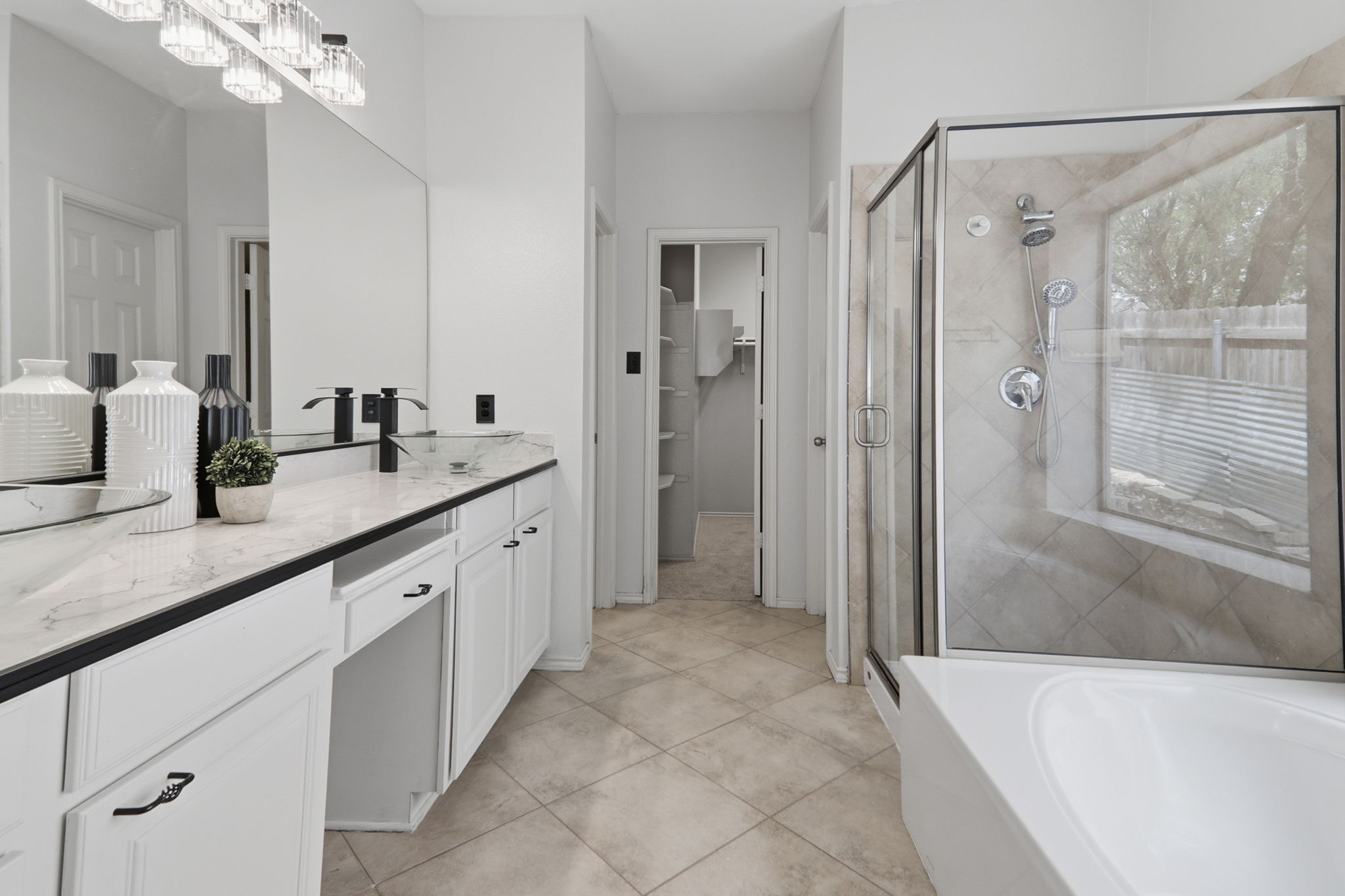 500 Red Hawk Drive Leander, TX 78641 - Photo 16 of 35 Bathroom featuring a bath, vanity, a shower stall, light tile patterned flooring, and a spacious closet