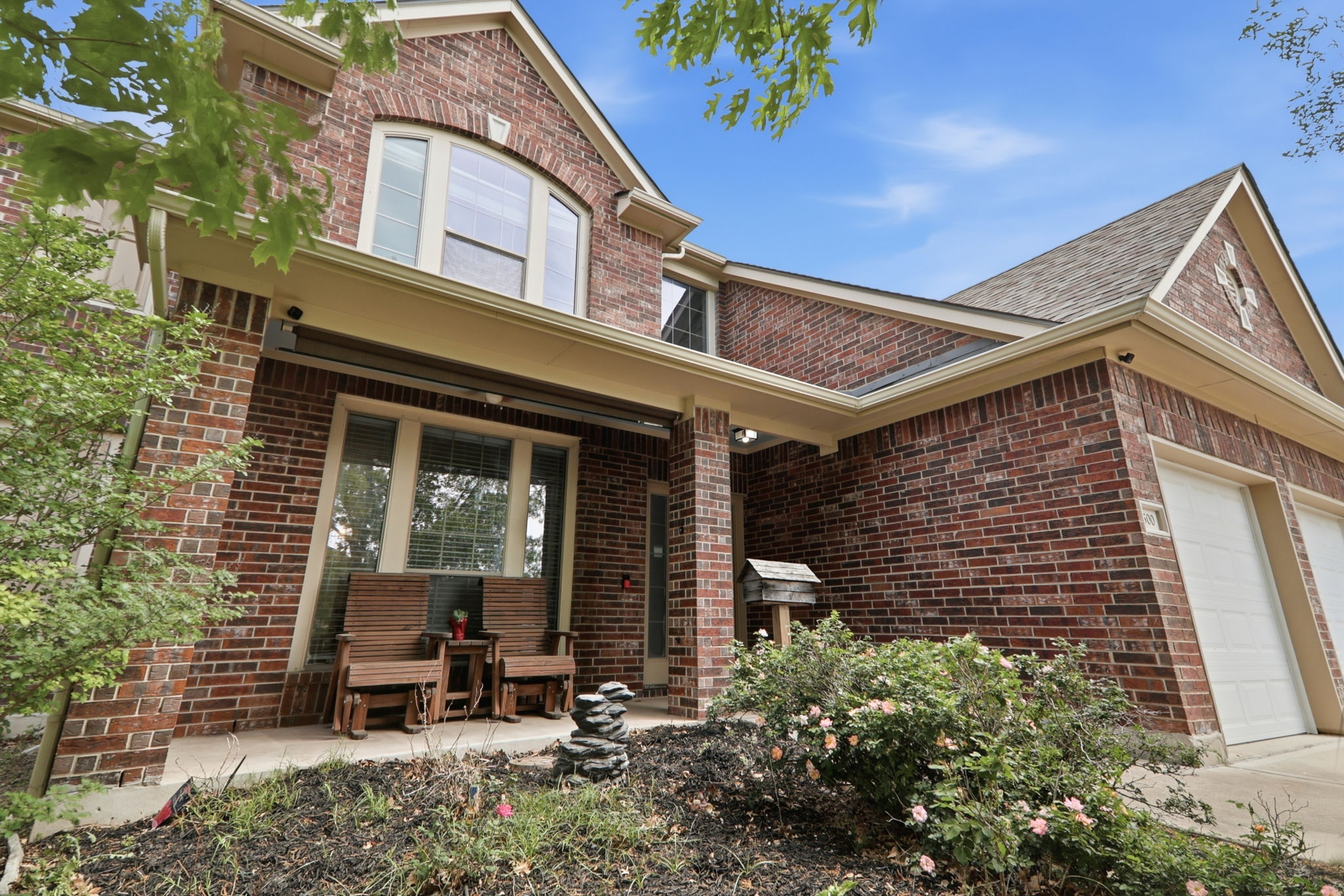 500 Red Hawk Drive Leander, TX 78641 - Photo 2 of 35 View of front of home featuring brick siding, an attached garage, roof with shingles, a patio, and concrete driveway