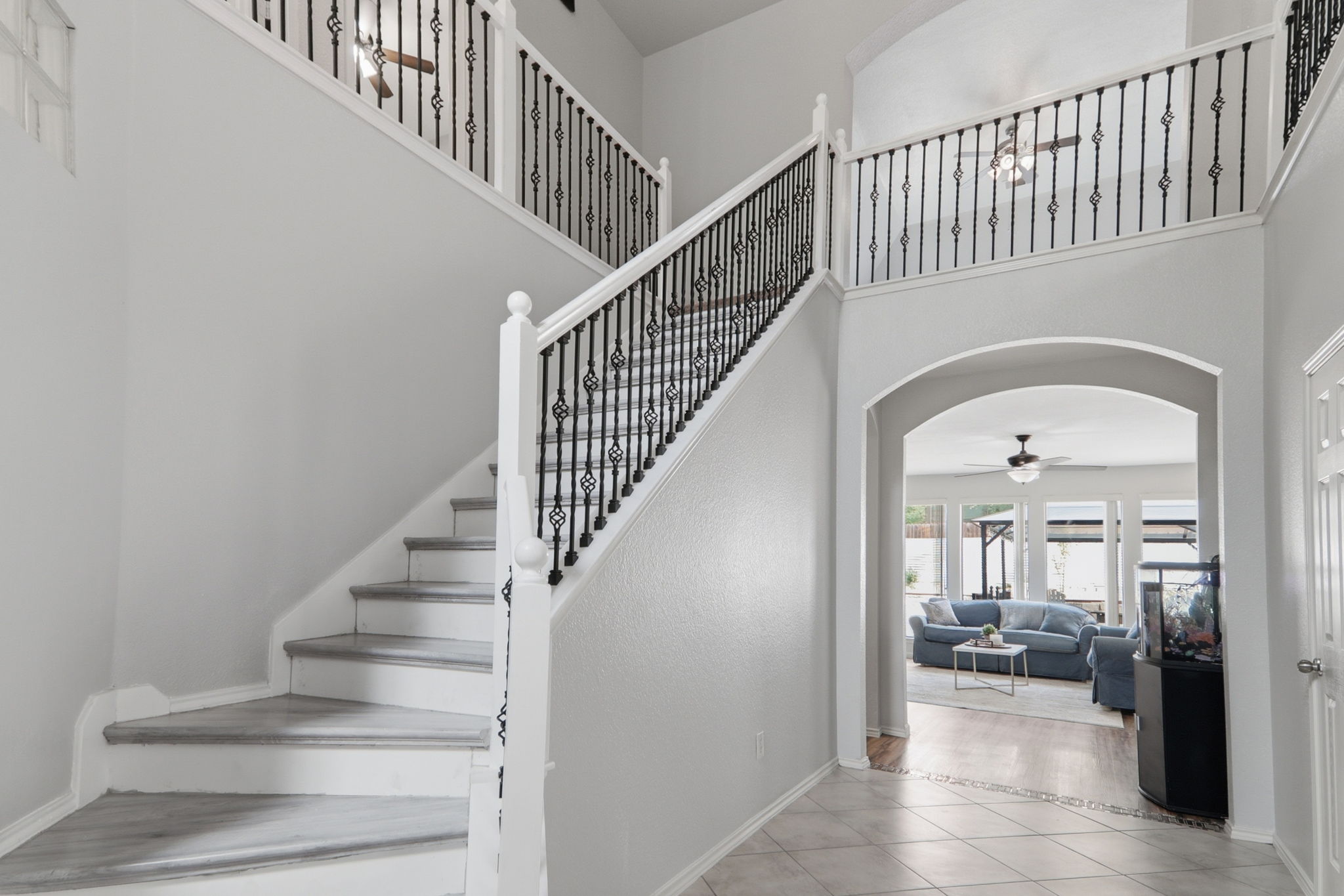 500 Red Hawk Drive Leander, TX 78641 - Photo 3 of 35 Stairway featuring arched walkways, ceiling fan, tile patterned flooring, and a high ceiling