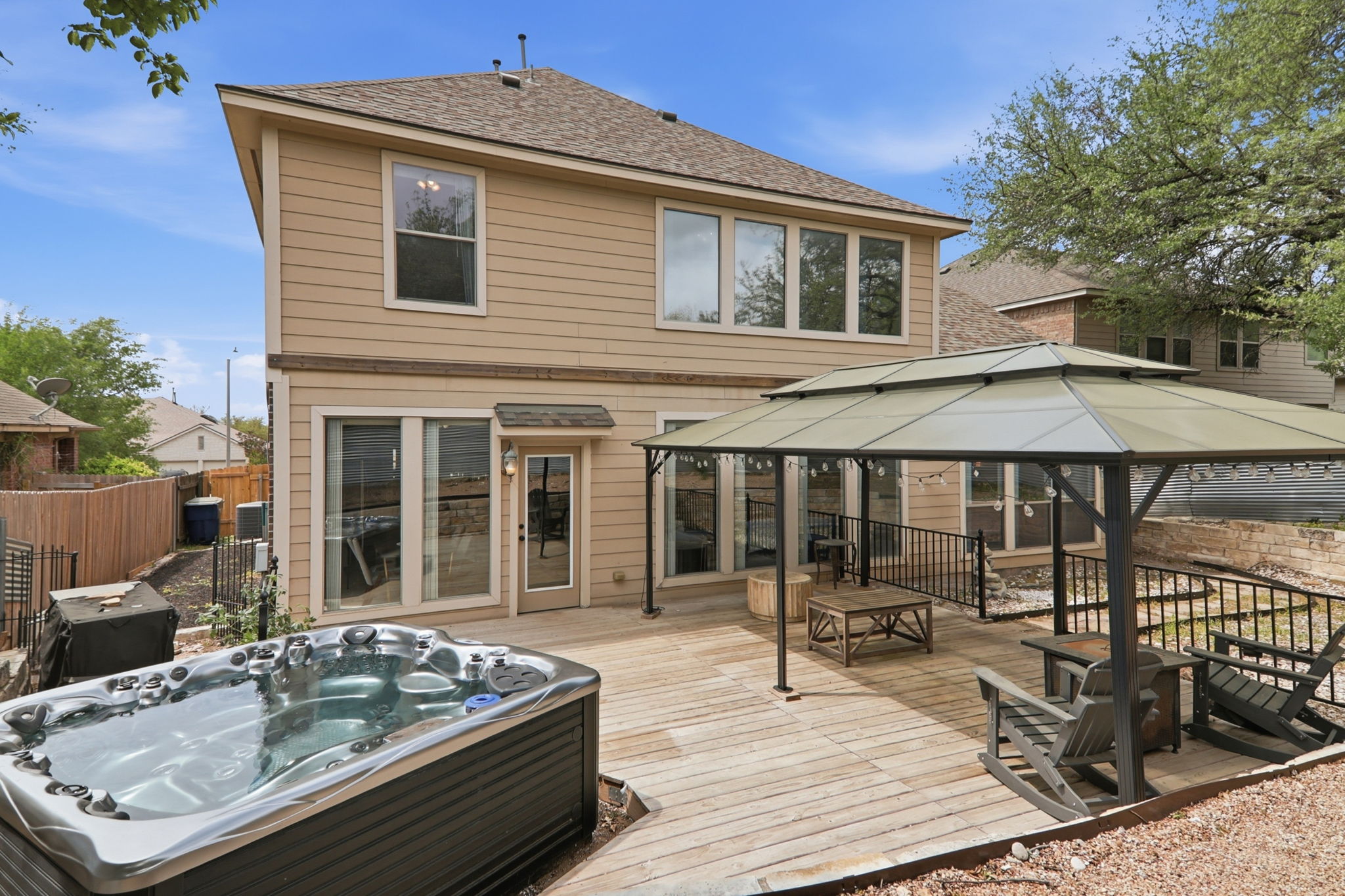 500 Red Hawk Drive Leander, TX 78641 - Photo 33 of 35 Back of house with a hot tub, a shingled roof, a gazebo, and a deck