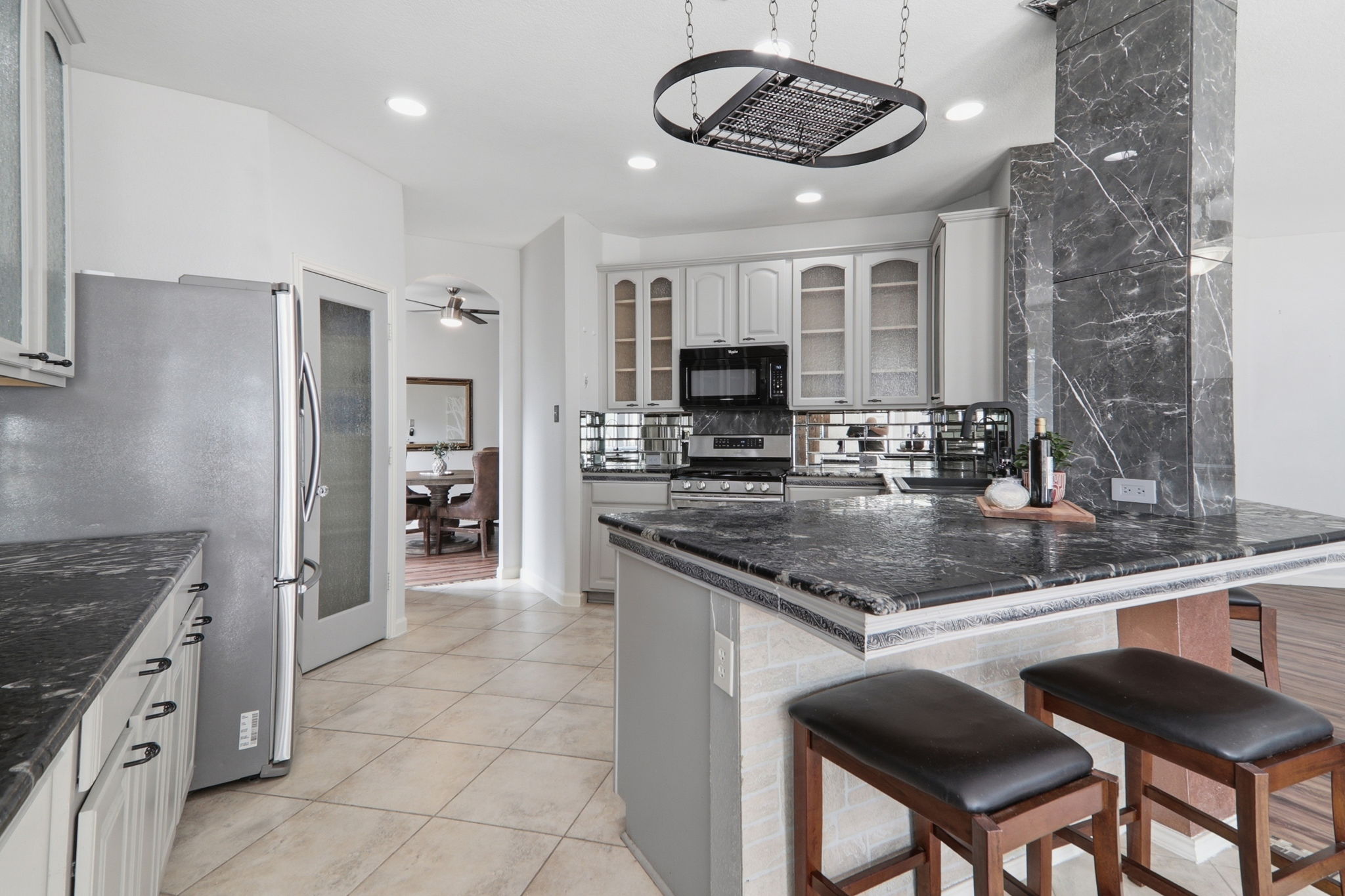 500 Red Hawk Drive Leander, TX 78641 - Photo 10 of 35 Kitchen featuring glass fronted cabinets, a kitchen breakfast bar, a peninsula, stainless steel appliances, and dark stone countertops