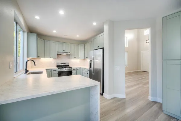 a kitchen with refrigerator cabinets and a sink
