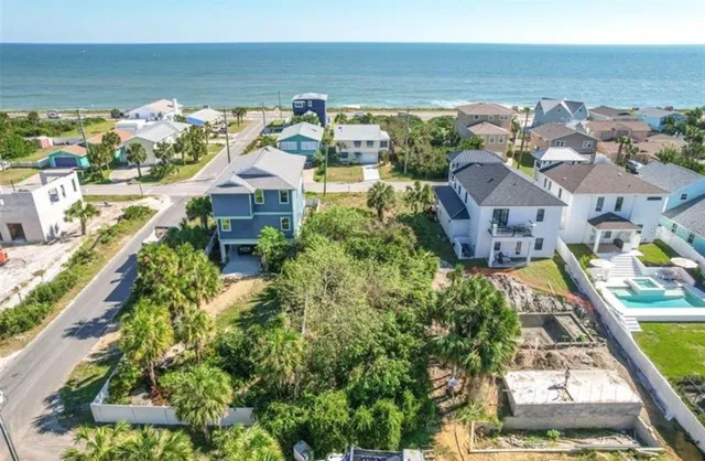 an aerial view of residential houses with outdoor space and ocean view