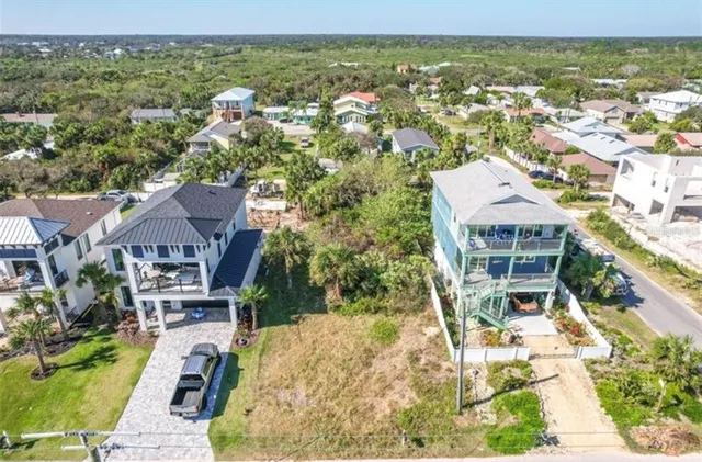 an aerial view of residential houses with outdoor space and trees