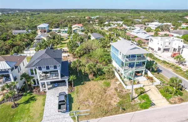 an aerial view of residential houses with outdoor space and trees