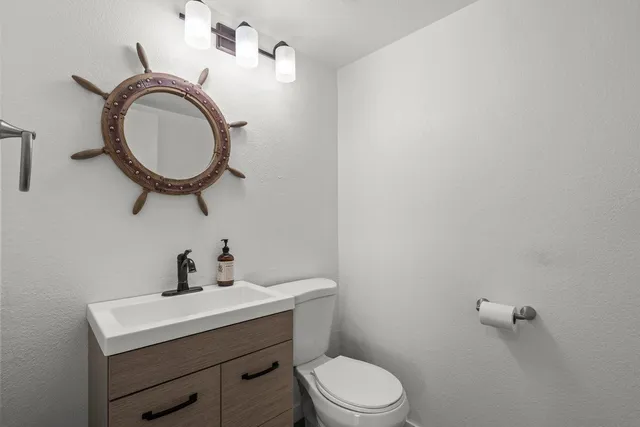 a bathroom with a toilet a sink and mirror