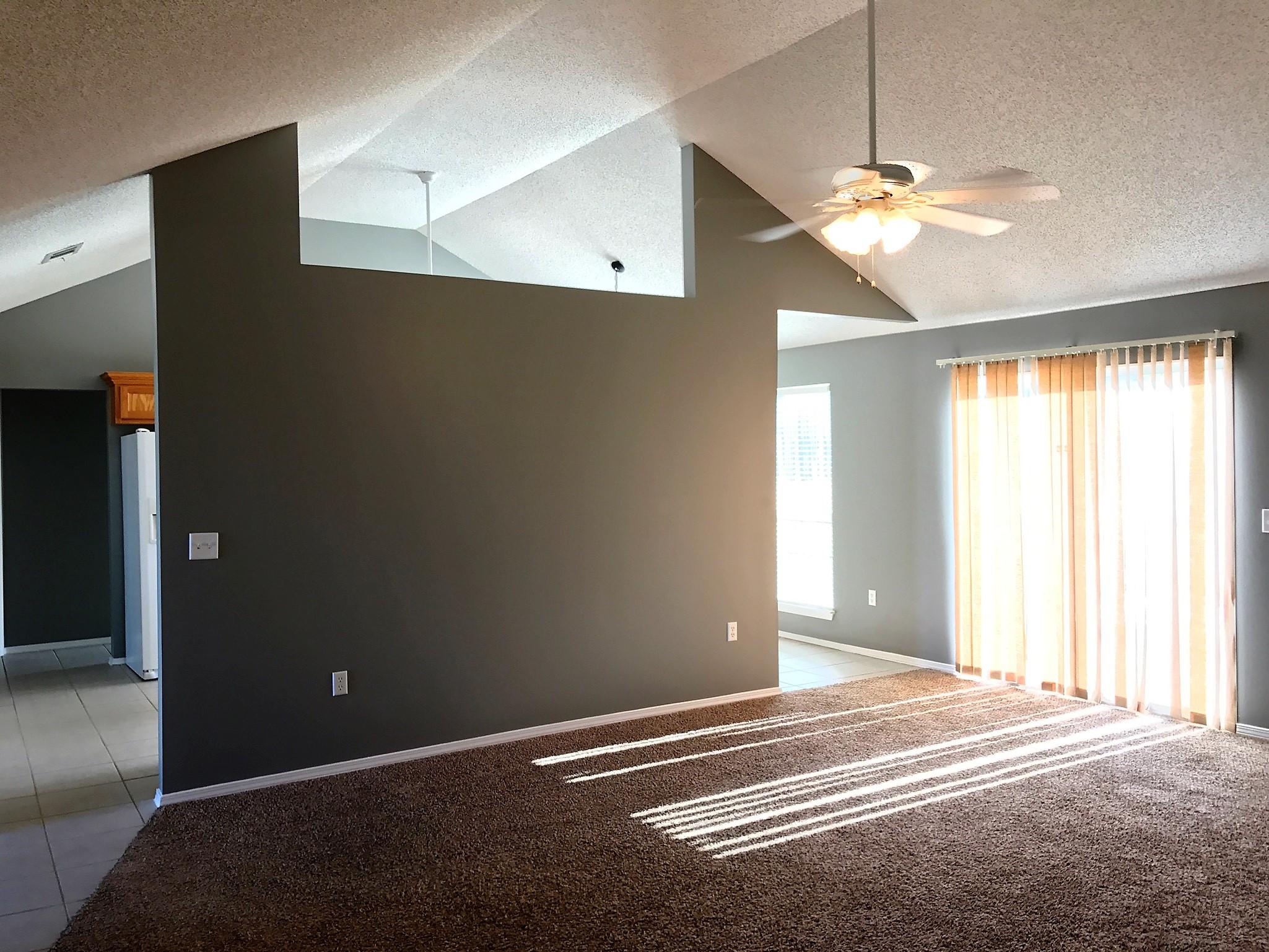 804 Travis Court Crestview, FL 32536 - Photo 4 of 22 a view of an empty room with window chandelier fan and a bathroom