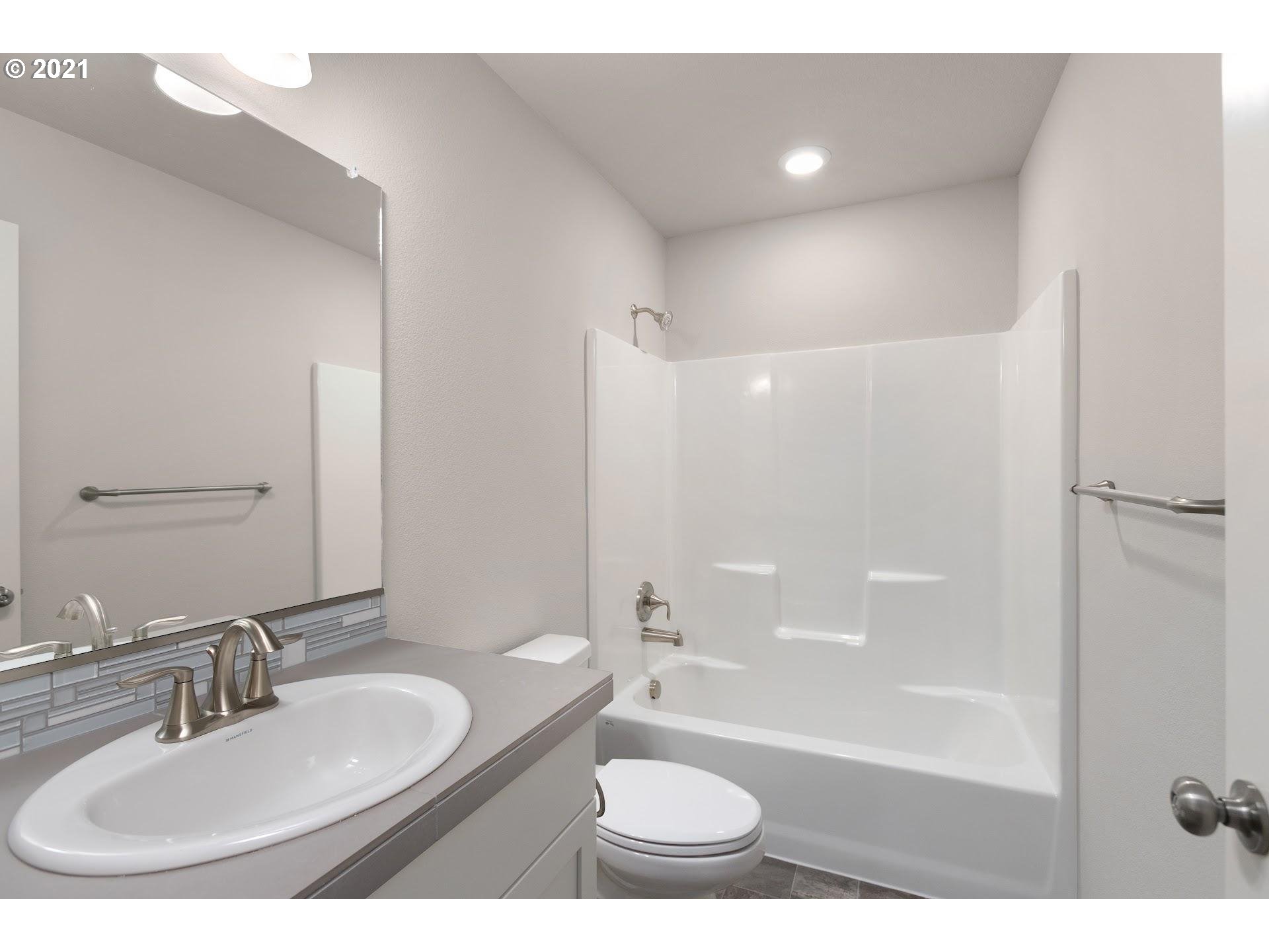 2364 South Brookside Place Ridgefield, WA 98642 - Photo 15 of 28 a bathroom with a bathtub shower sink vanity mirror and toilet