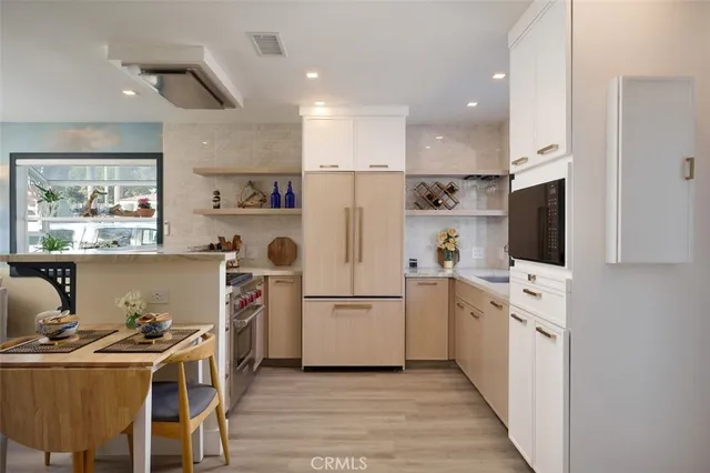 a kitchen with white cabinets and stainless steel appliances