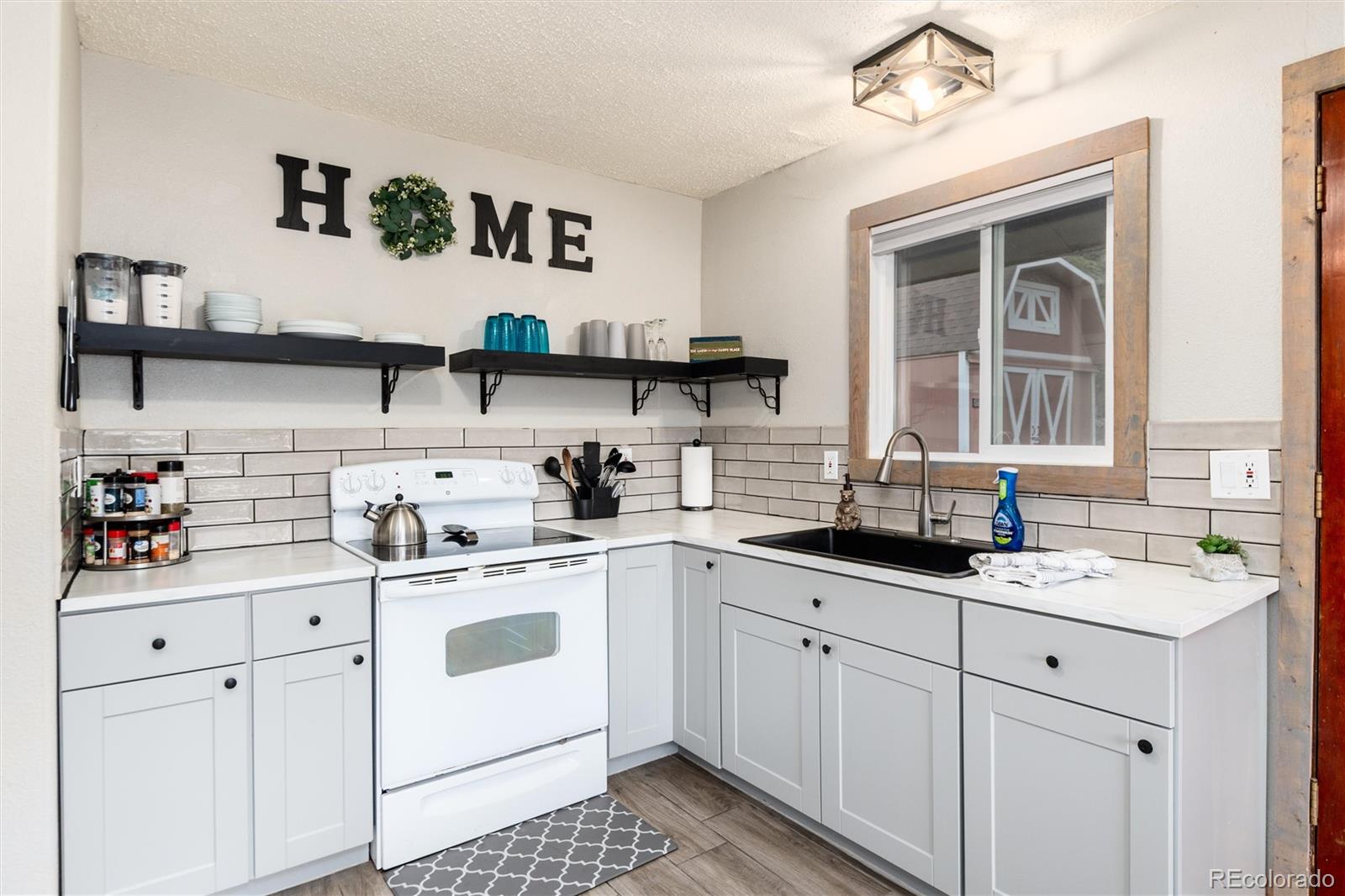 159 Lake Road Idaho Springs, CO 80452 - Photo 4 of 45 a kitchen with white cabinets and white appliances