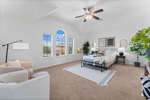 a bedroom with furniture and a large window