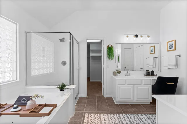 a spacious bathroom with a tub sink and mirror