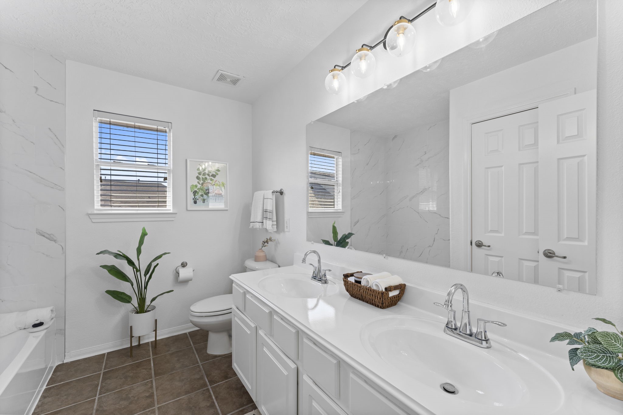 21418 Avalon Queen Drive Spring, TX 77379 - Photo 23 of 35 a bathroom with a granite countertop sink a large mirror a bathtub and next to a window