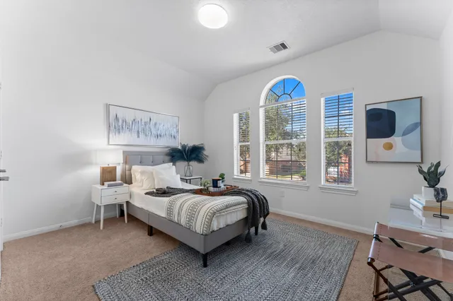 a bedroom with a bed and a table in it with window