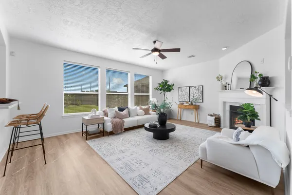 a living room with furniture large window and wooden floor