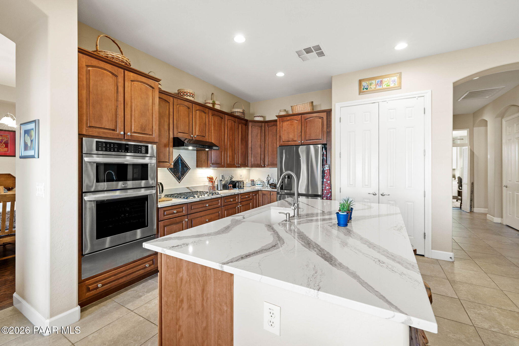 1636 Constable Street Prescott, AZ 86301 - Photo 16 of 41 a kitchen with stainless steel appliances kitchen island granite countertop a refrigerator oven a sink dishwasher and white cabinets with wooden floor