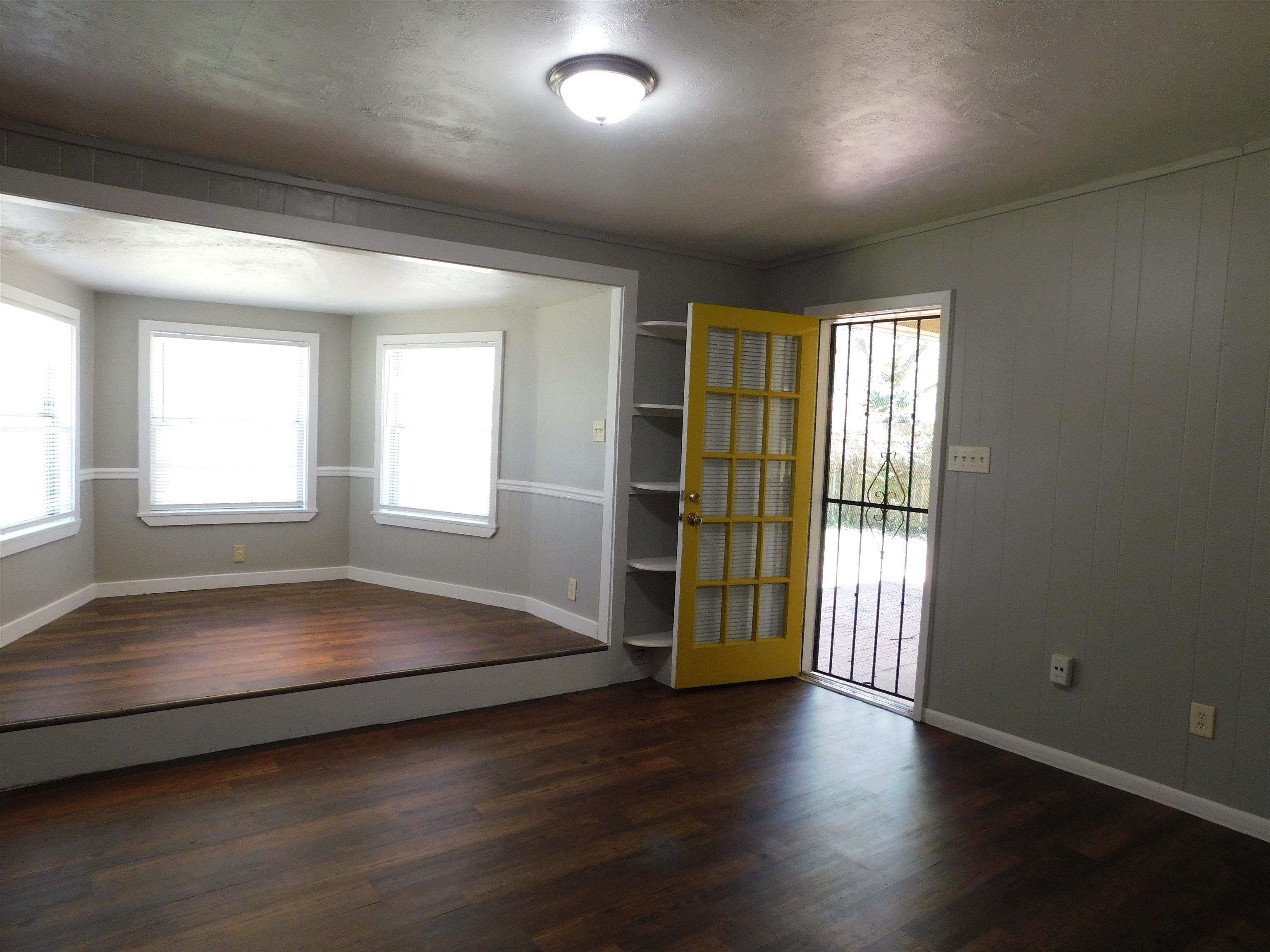 5588 Loch Lomond Road Memphis, TN 38116 - Photo 15 of 16 an empty room with wooden floor and windows
