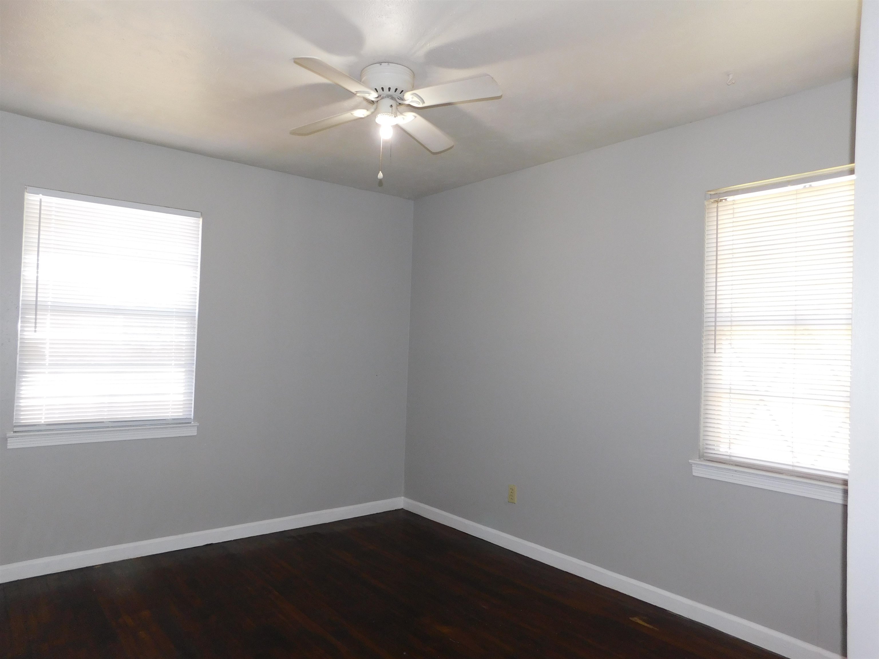 5588 Loch Lomond Road Memphis, TN 38116 - Photo 8 of 16 an empty room with wooden floor and windows