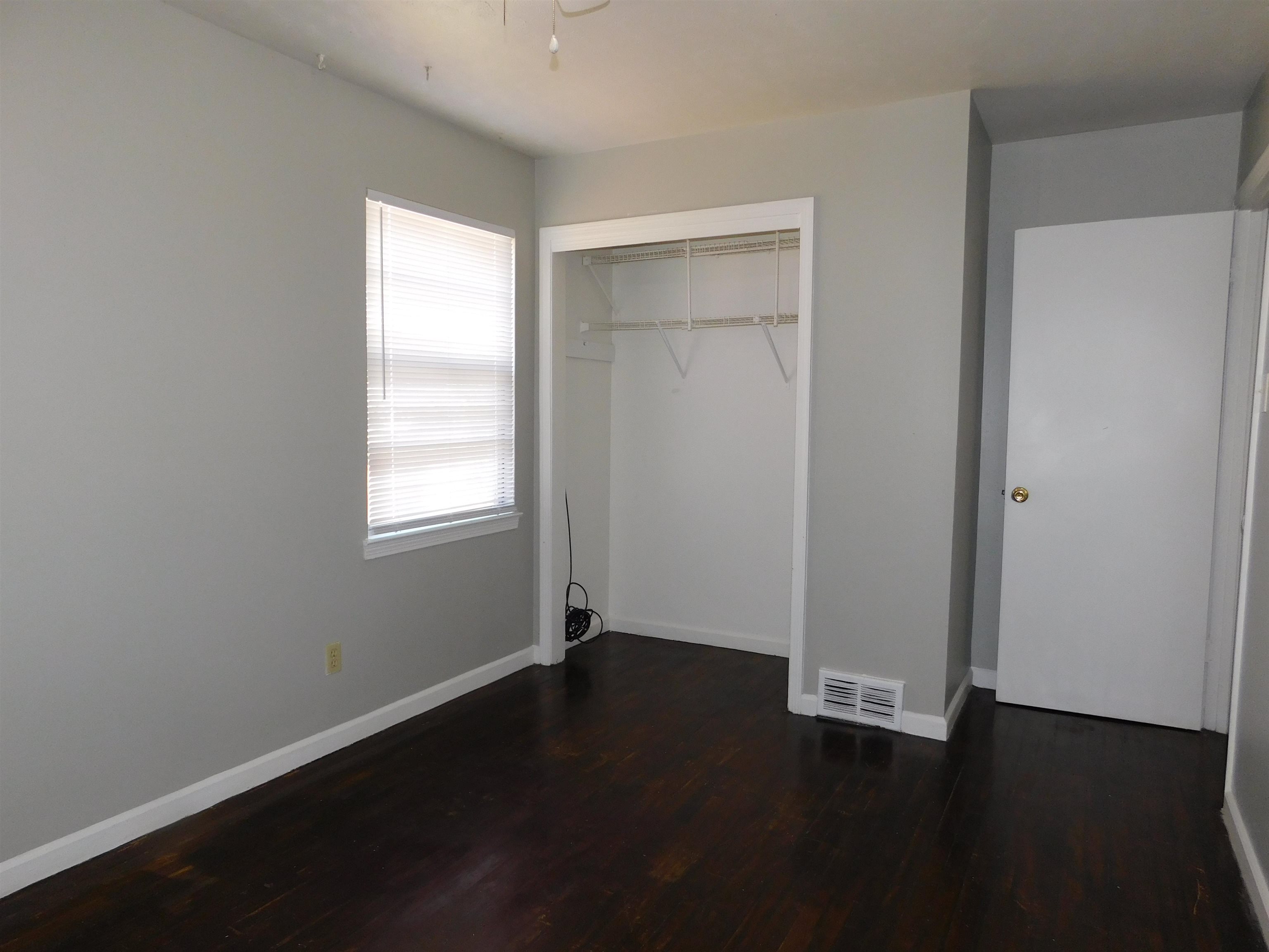 5588 Loch Lomond Road Memphis, TN 38116 - Photo 9 of 16 an empty room with wooden floor and windows