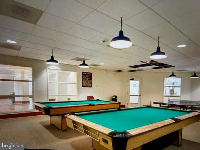 a room with pool table table and windows