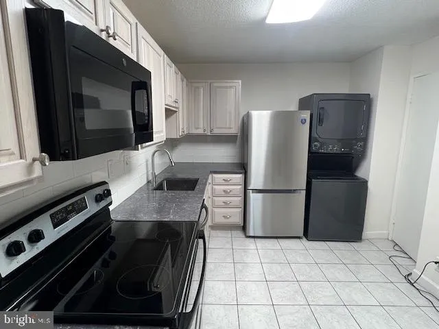 a kitchen with a refrigerator and a stove top oven