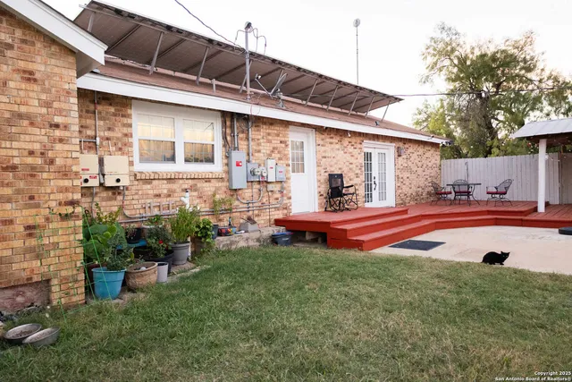 a backyard of a house with table and chairs