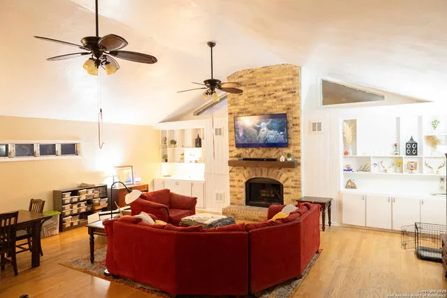a living room with furniture a fireplace and a flat screen tv