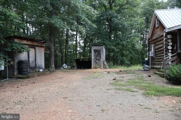 a view of a house with backyard and trees
